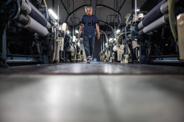 In this picture taken on September 4, 2024, weaving craftsman Shigeru Uchida walks between looms to detect unusual sounds that could signal a breakdown at the Momotaro Jeans factory in the Kojima district of Okayama. — AFP pic 