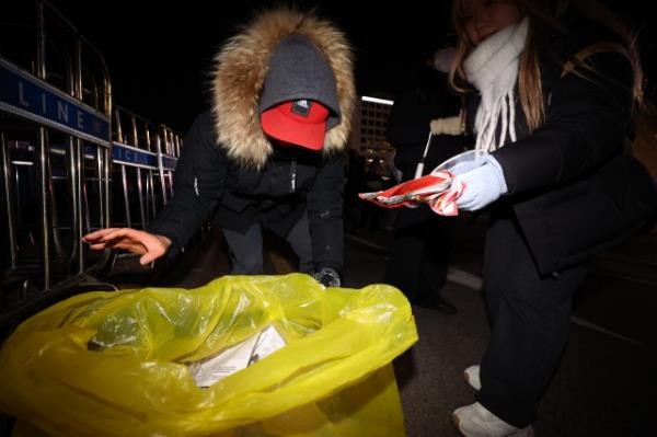Citizens clean up trash following Saturday’s impeachment rally for Yoon Suk Yeol near the Natio<em></em>nal Assembly in Yeouido, Seoul. (Newsis)